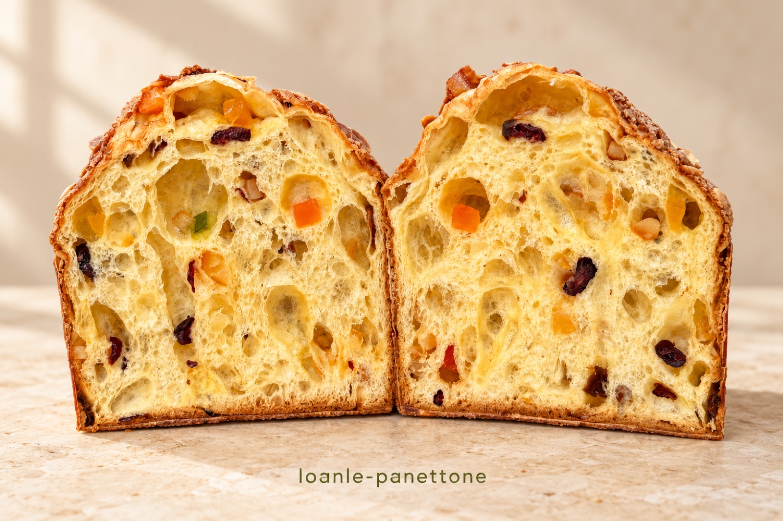 Hai nửa panettone của tiệm, ruột bánh vàng có thớ, nho khô và mứt vỏ cam